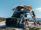 Person Climbing Inside The Front Runner Roof Top Tent While Another Person Is Sitting Next To It